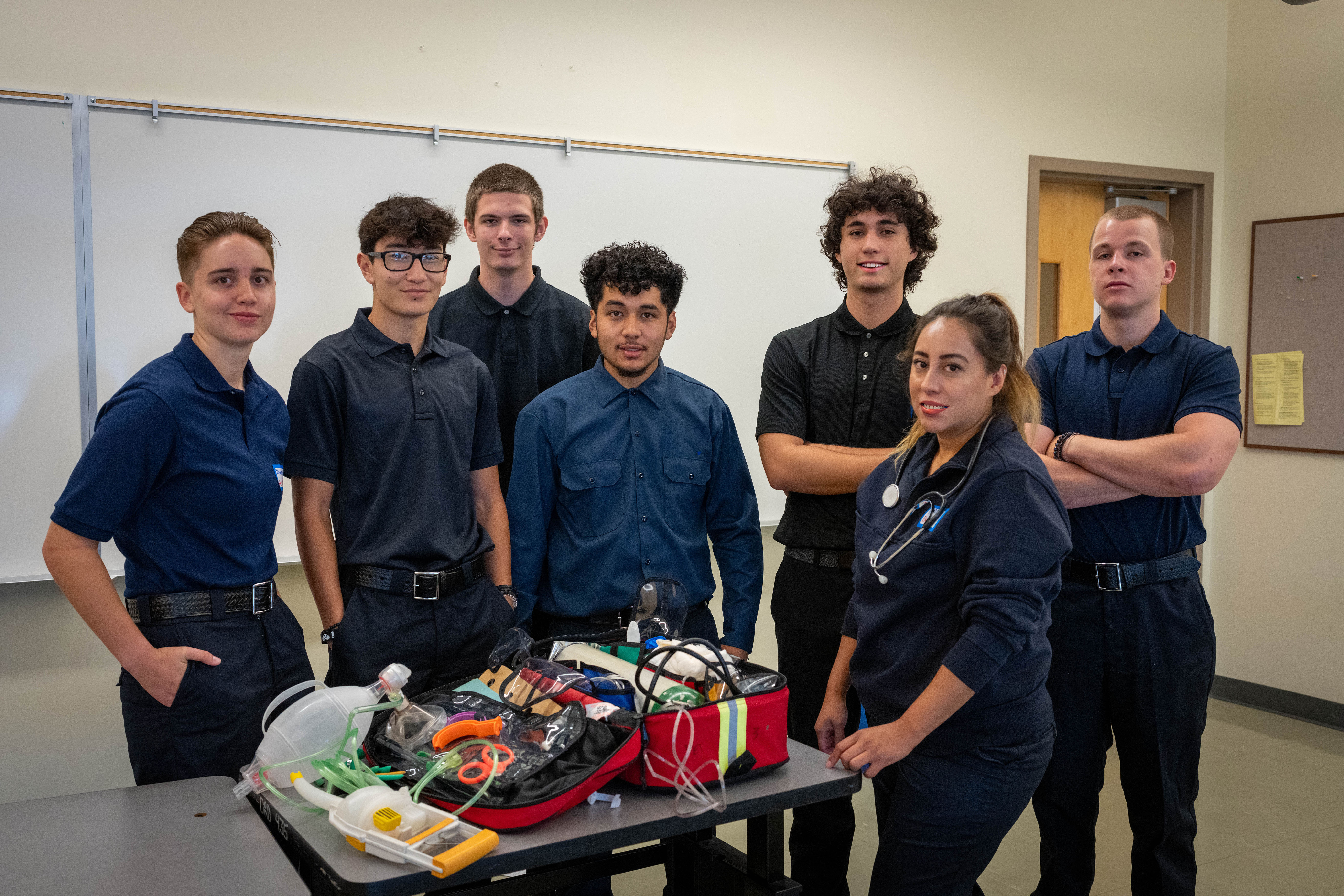 SRJC EMR students posing as a group, with an open medical responder bag in front of them