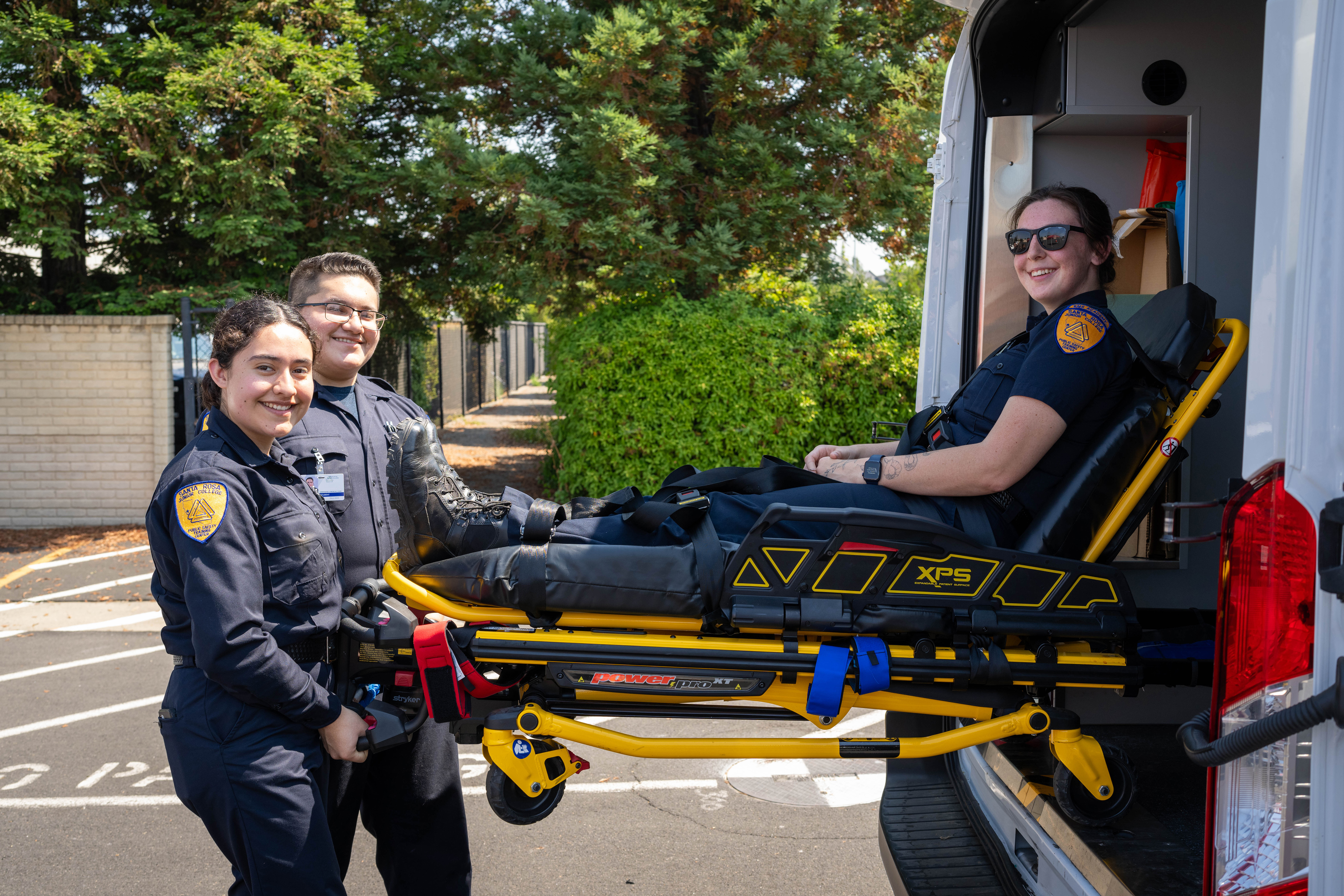 Two SRJC EMT students practicing the loading of a stretcher into the back of an ambulance